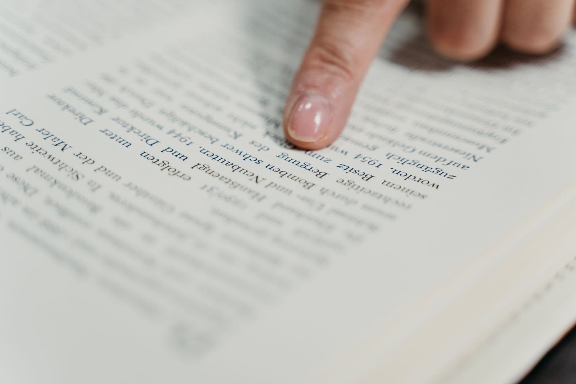 Mão grifando um trecho de texto impresso