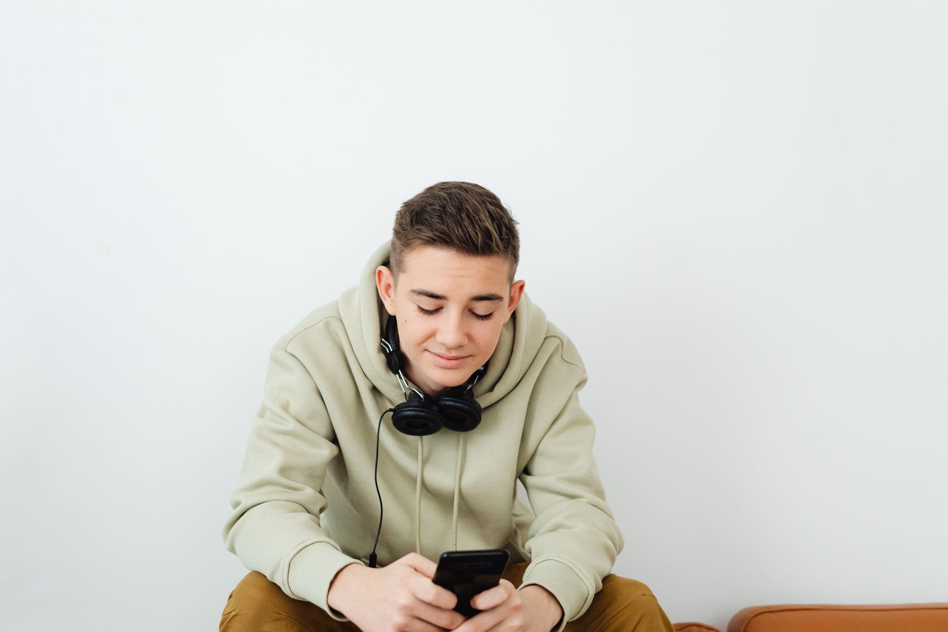 Adolescente estudando pelo celular com fones de ouvido